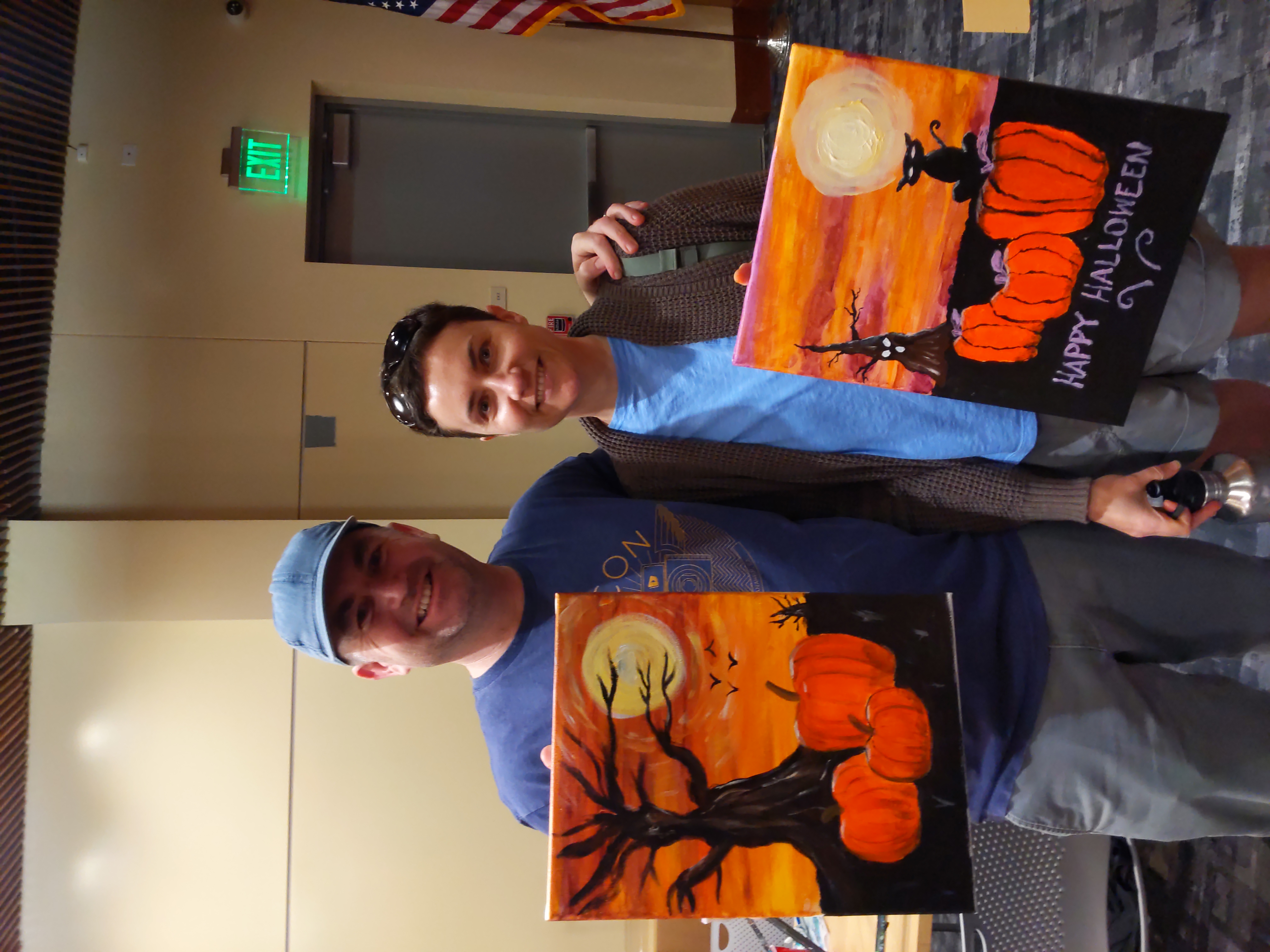 chris and kristen standing with paintings